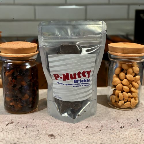 P-Nutty Brickle Bag on counter with raisins and peanuts in jars